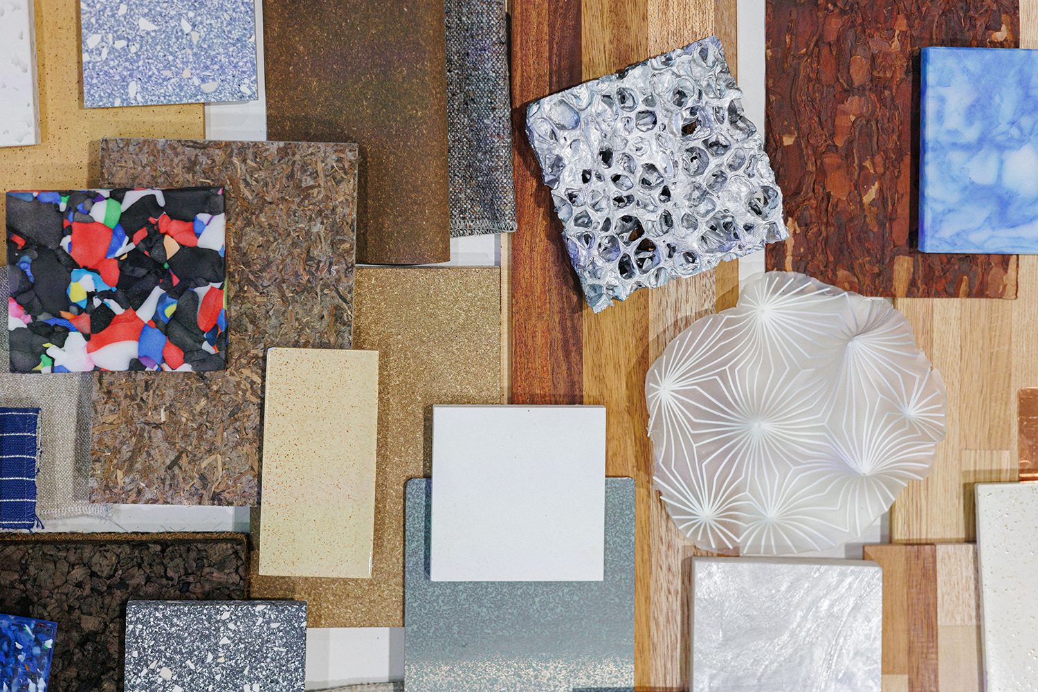 Erilaisia materiaalinäytteitä aseteltuna pöydälle