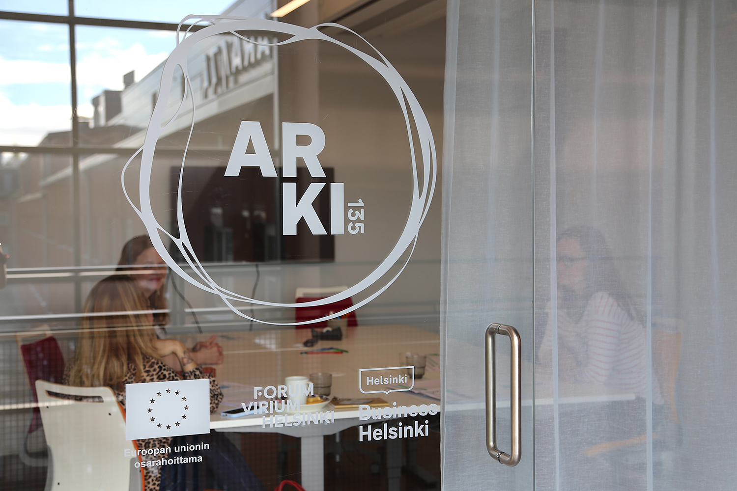 A white ARKI 135 logo on a glass wall surface.