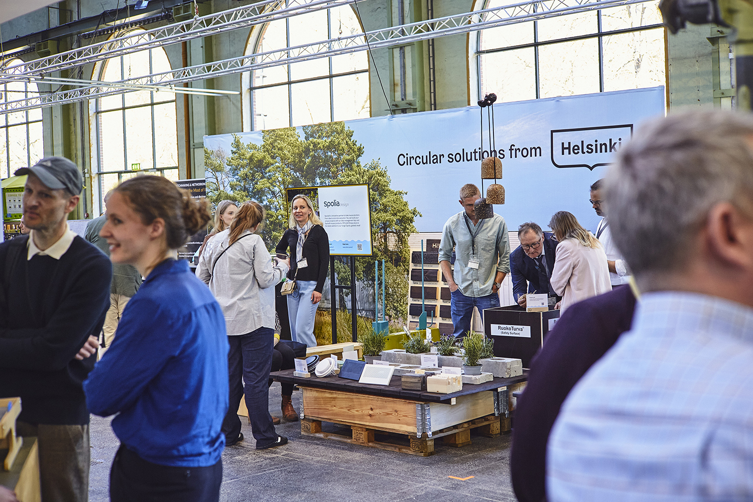 Several people standing in an exhibition stand with the text "Circular solutions from Helsinki" on the wall behind.